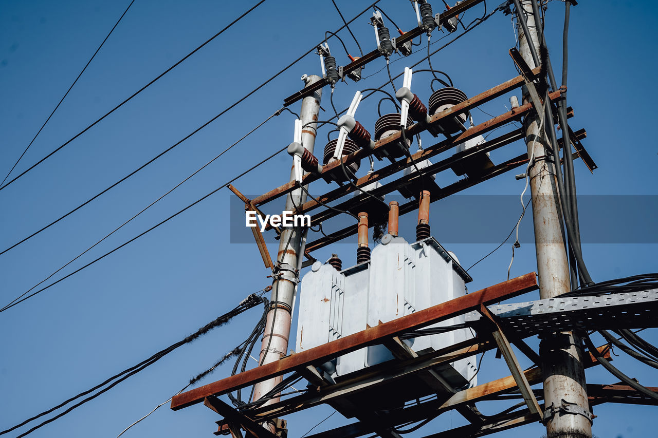 Low angle view of electricity pylon against clear sky