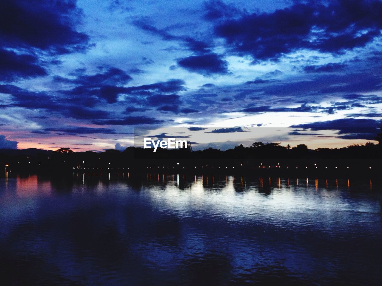 SCENIC VIEW OF SEA AGAINST CLOUDY SKY AT DUSK