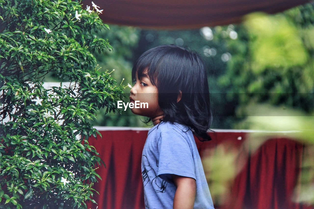 Portrait of girl walking by plants