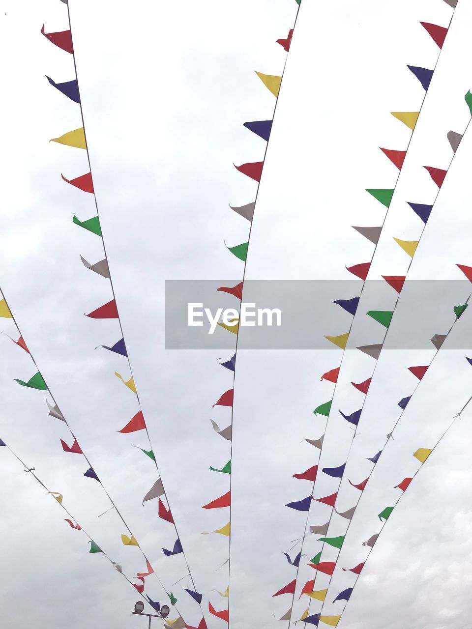 Low angle view of bunting hanging against sky