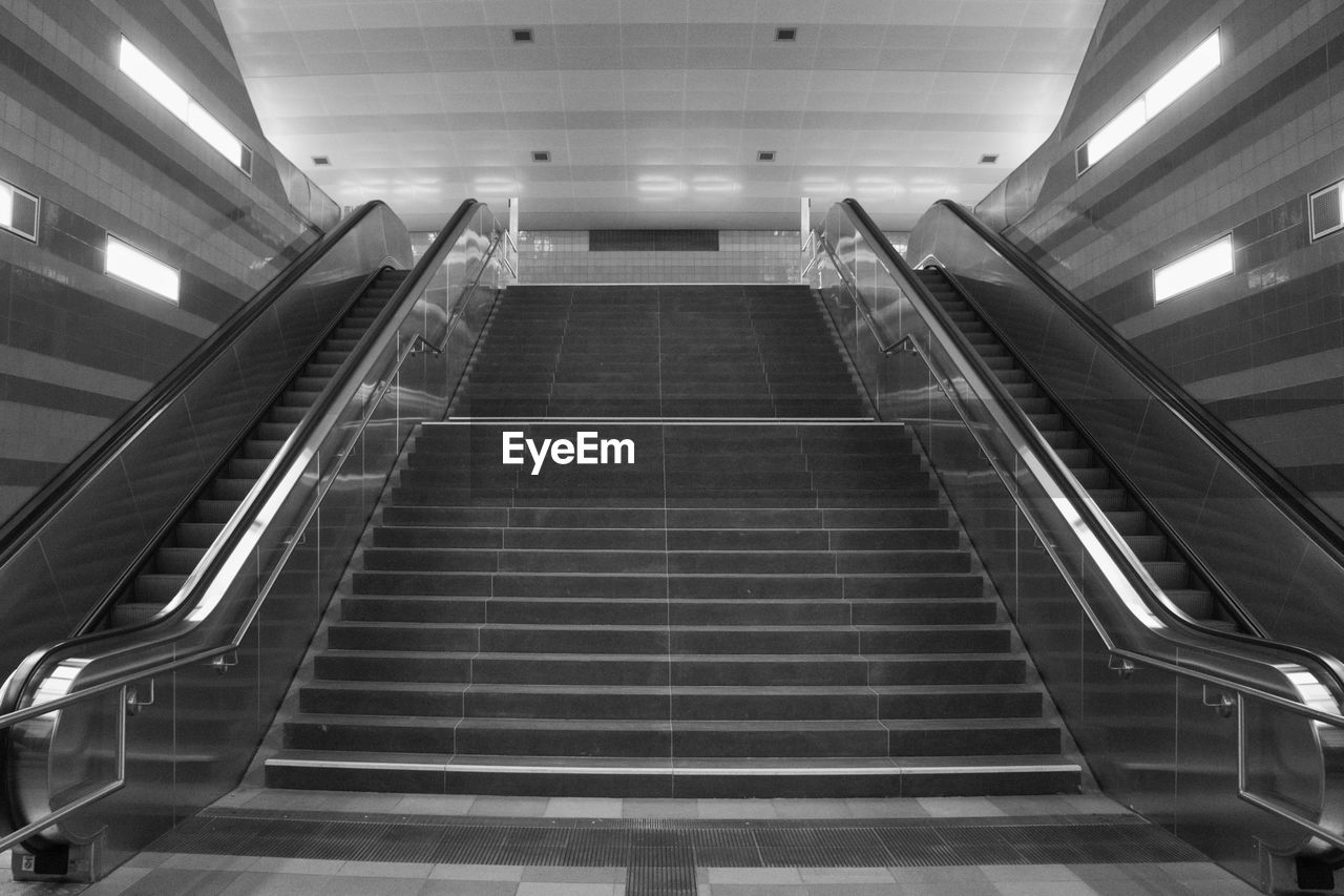 LOW ANGLE VIEW OF ESCALATOR IN ILLUMINATED UNDERGROUND