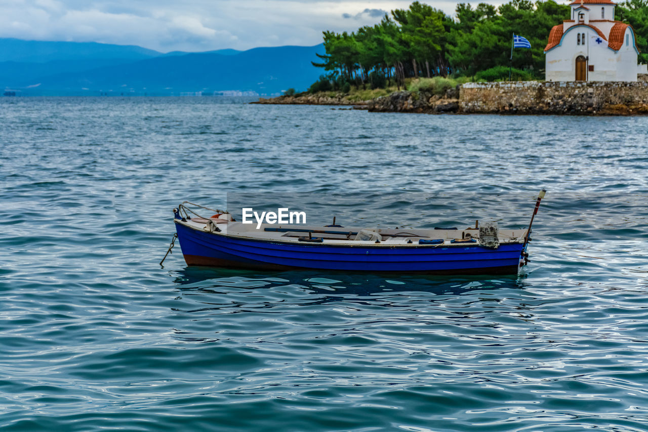 SAILBOAT MOORED IN SEA AGAINST SKY