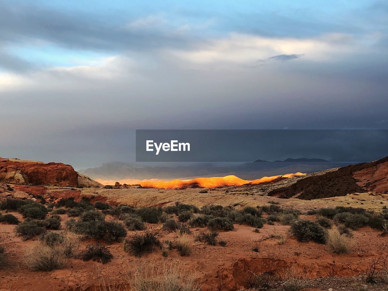 View of desert against cloudy sky