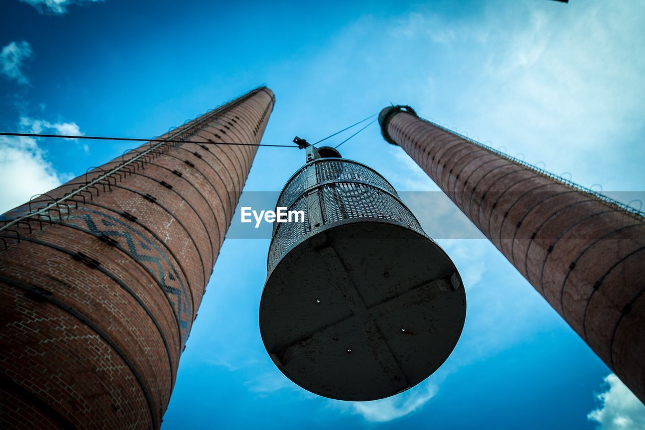 Directly below shot of elevator amidst chimneys