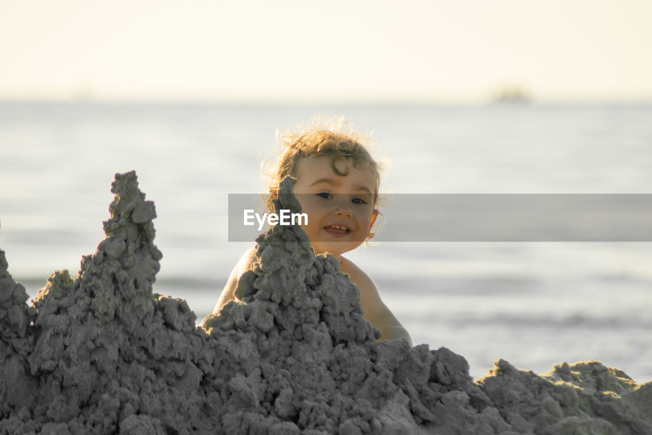 Toddler playing with sand on the beach