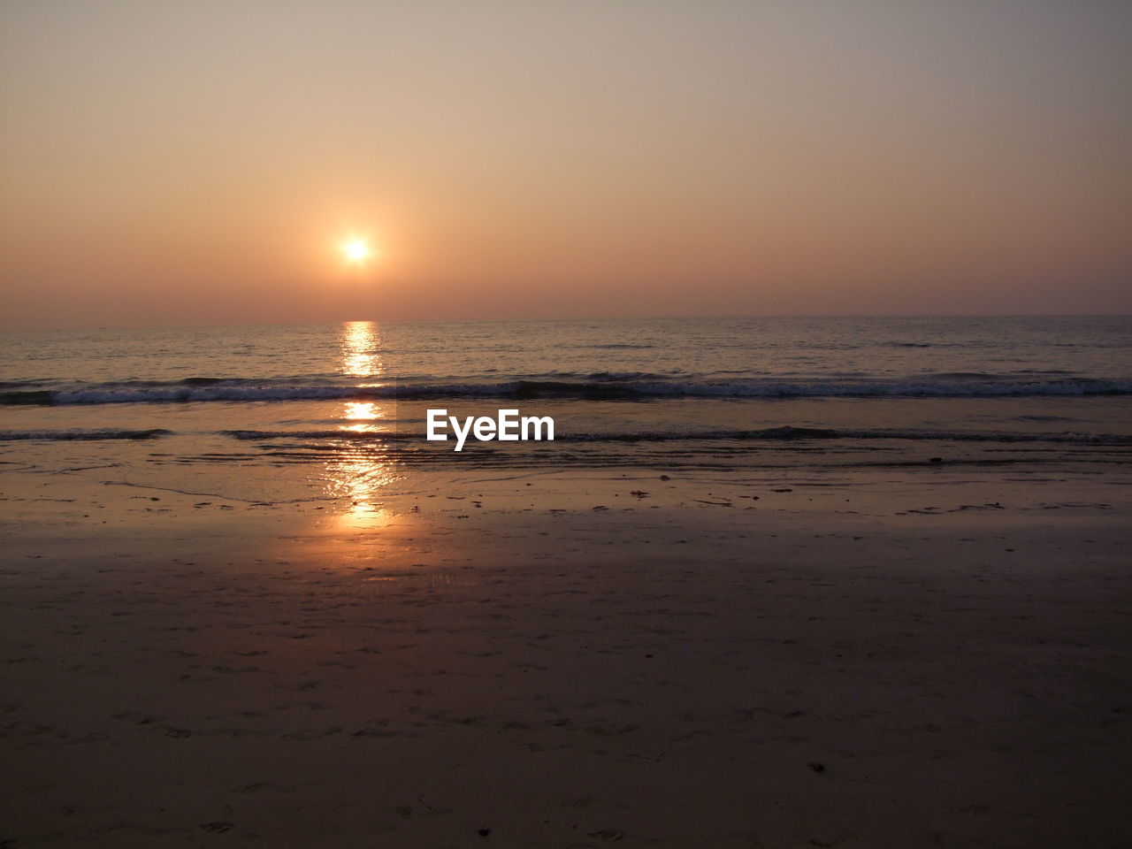 SCENIC VIEW OF BEACH AGAINST SKY AT SUNSET