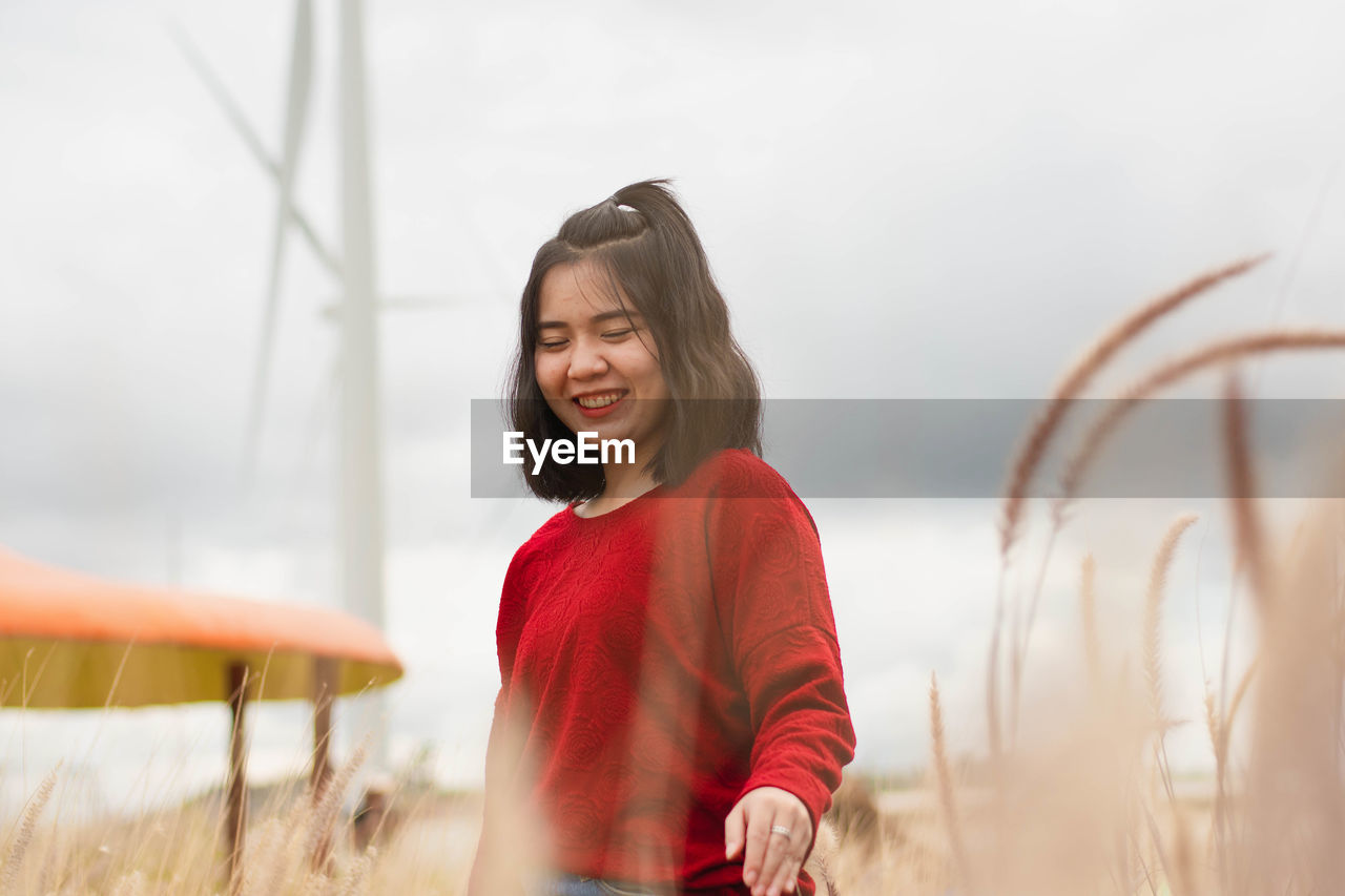 Happy young woman standing on field