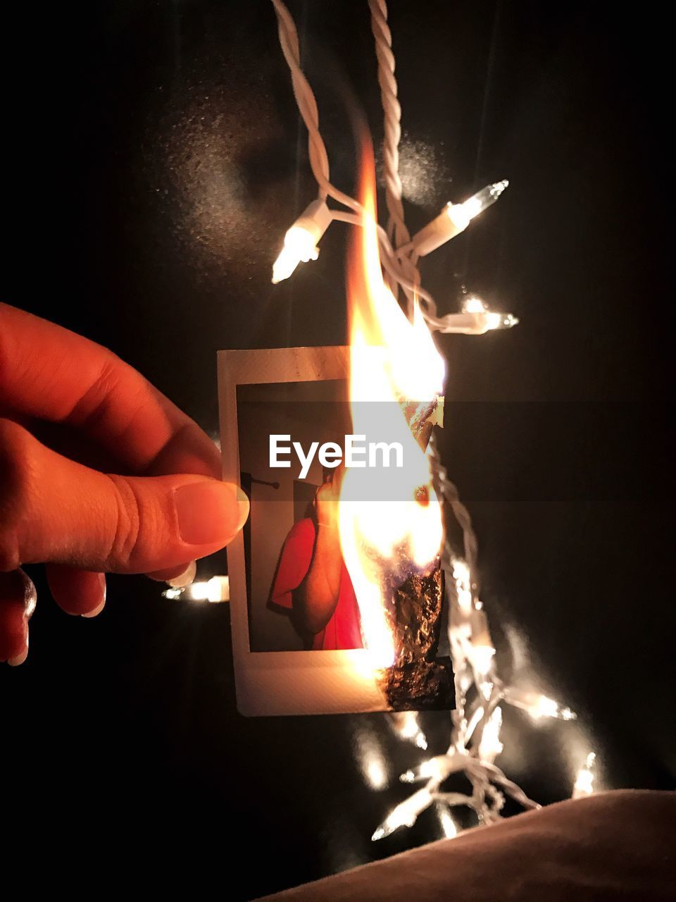 Close-up of hands burning a photograph