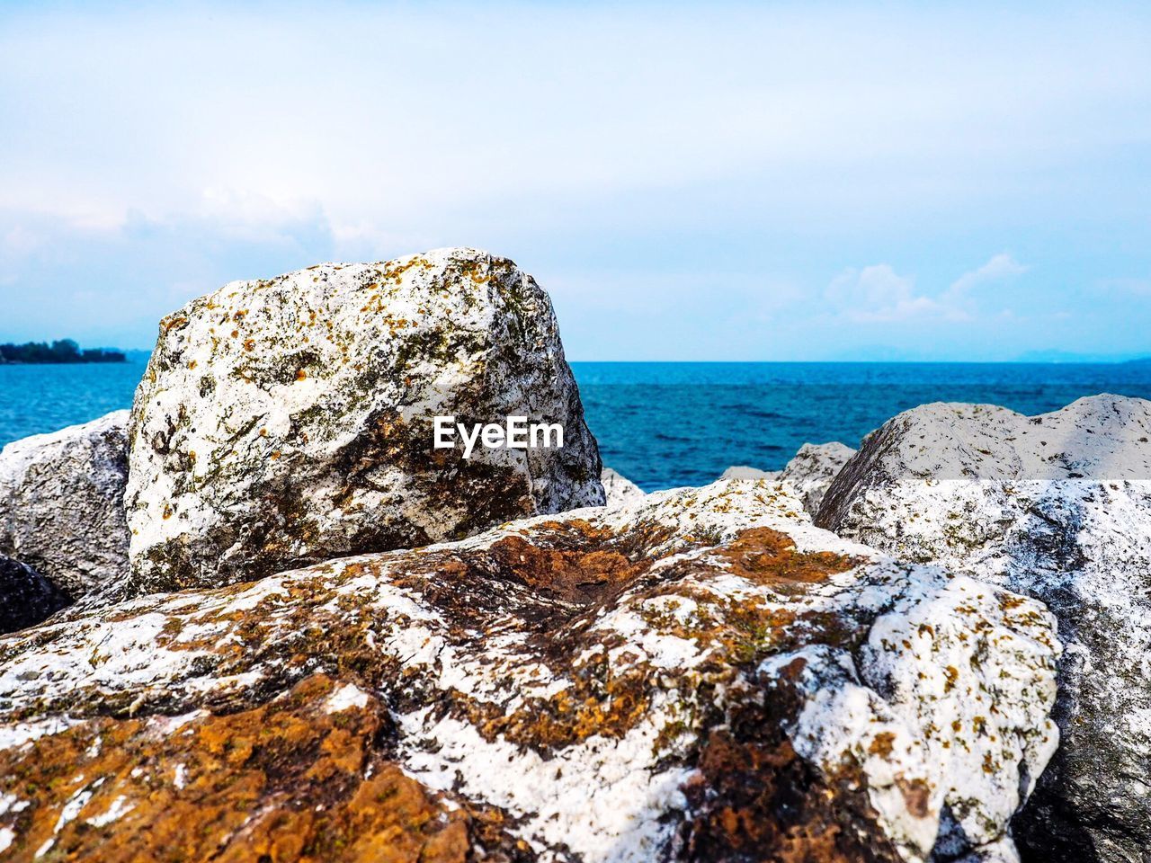 CLOSE-UP OF ROCKS IN SEA AGAINST SKY