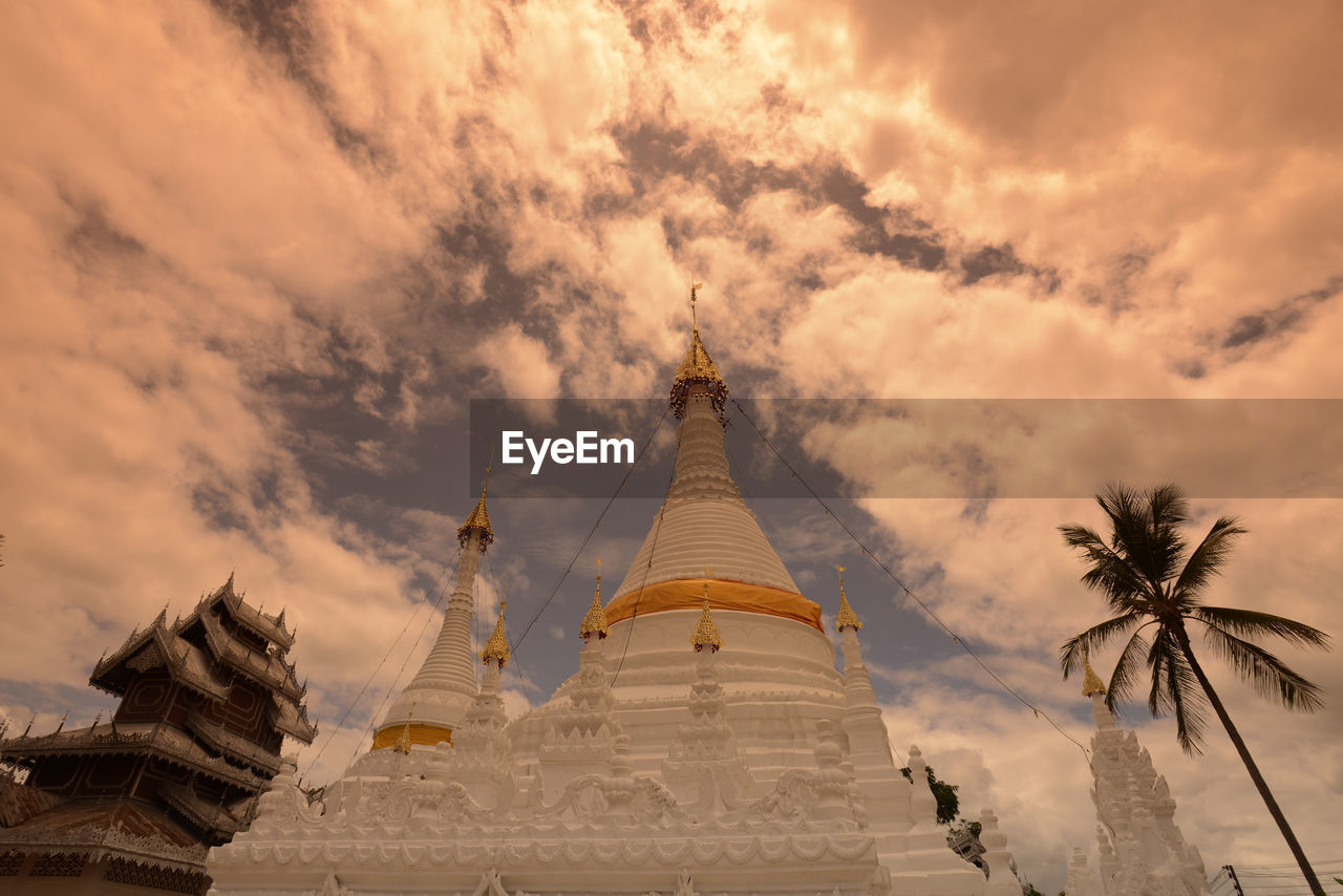 Low angle view of pagoda against cloudy sky during sunset