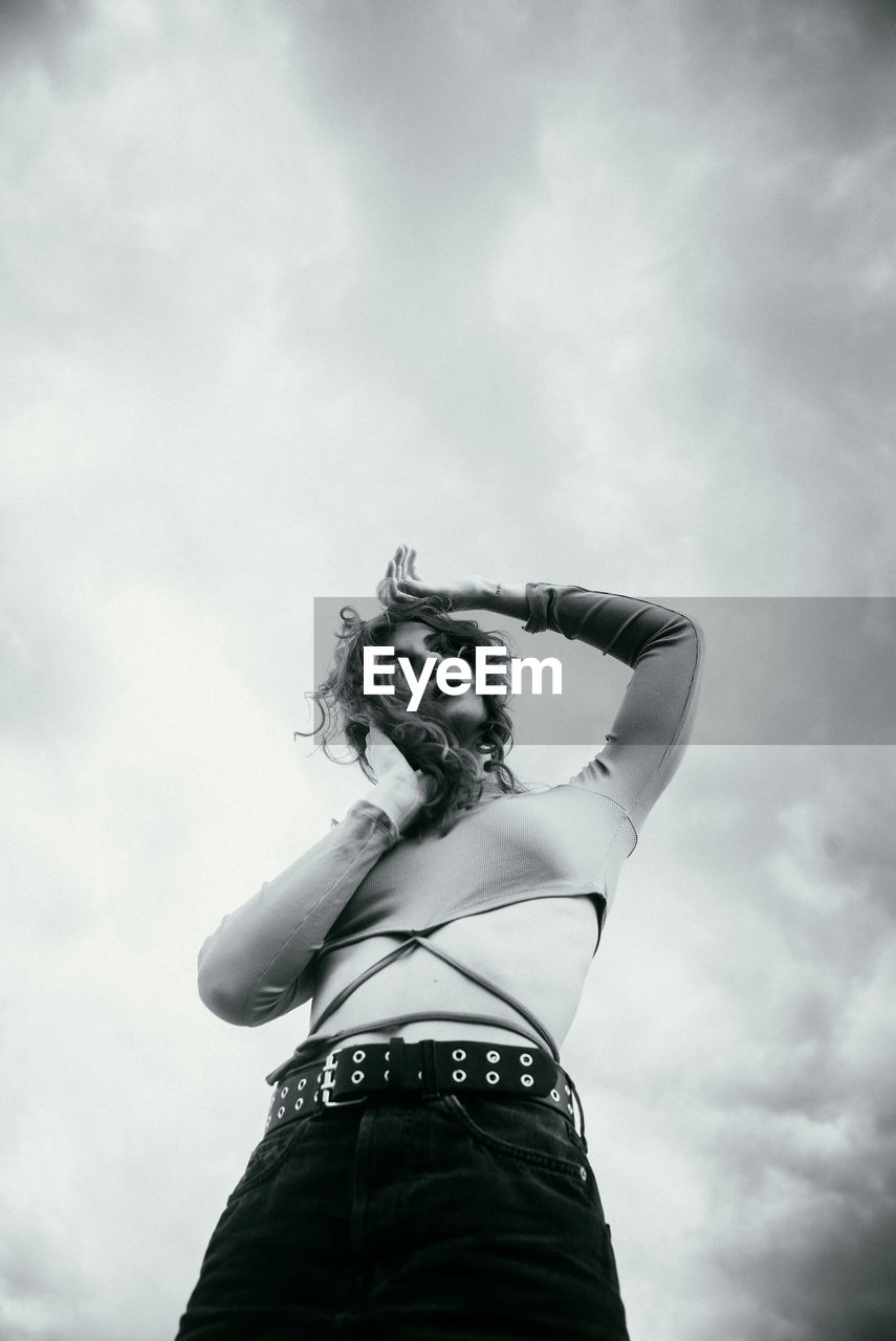Low angle view of woman standing against sky