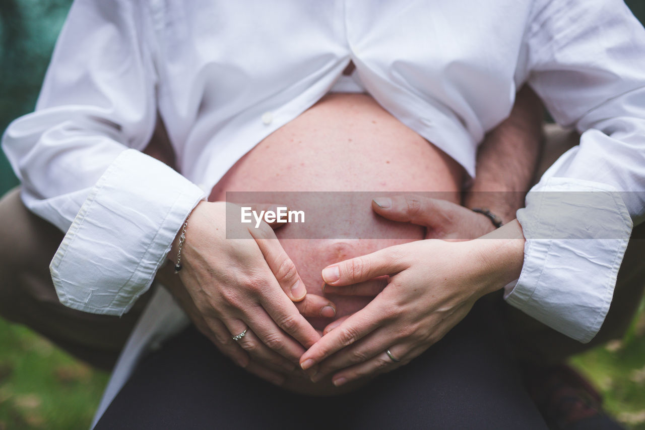 MIDSECTION OF MAN TOUCHING HEAD OF PERSON WITH EYES