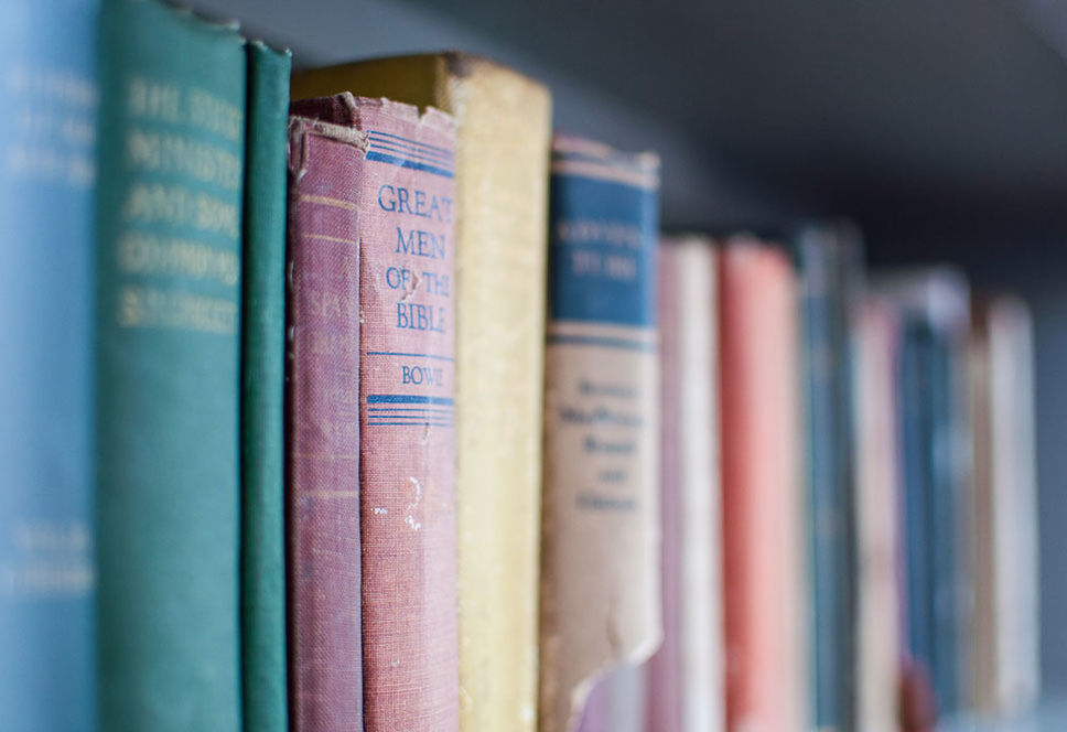 CLOSE-UP OF BOOKS ON SHELF AT HOME