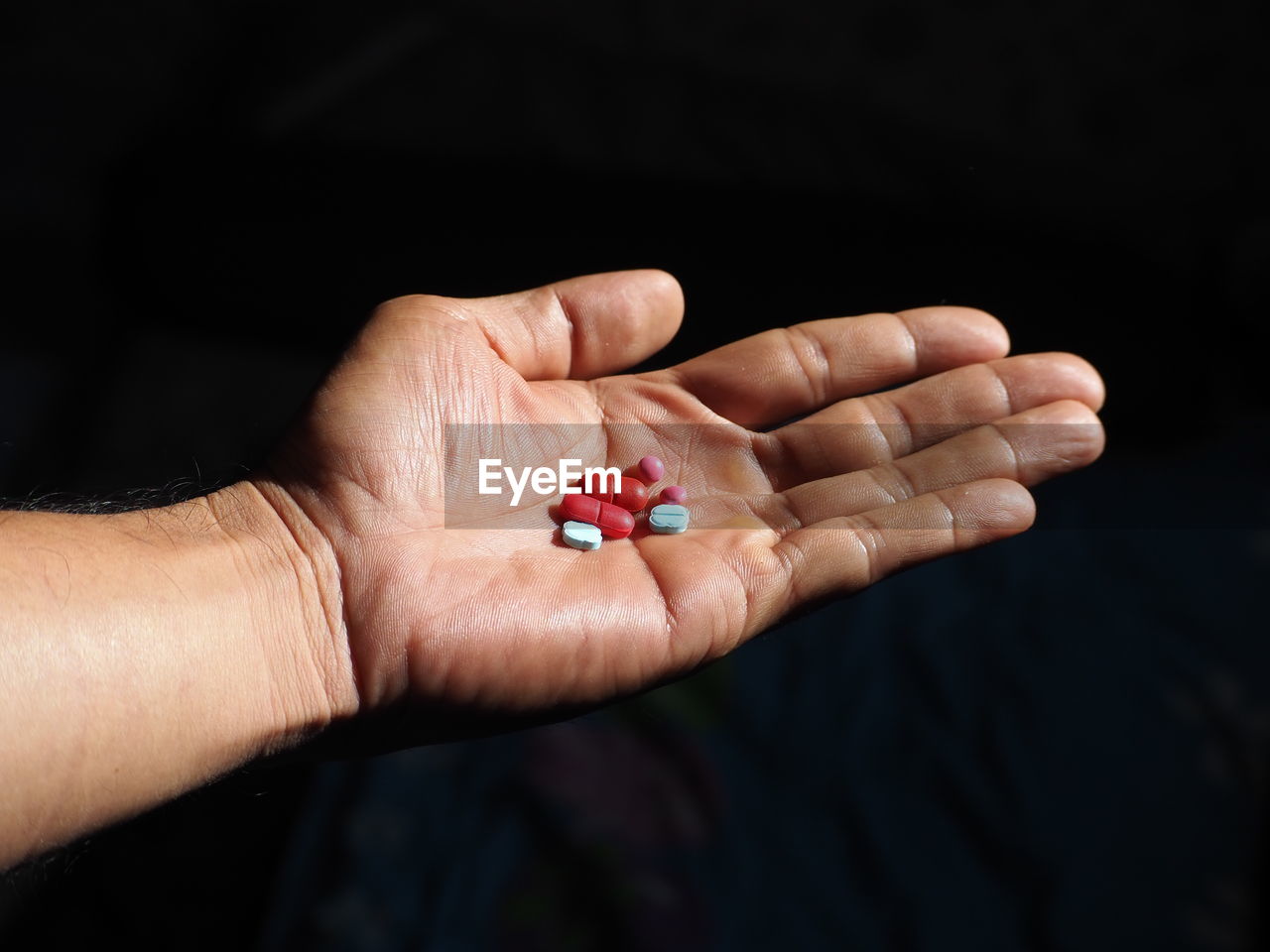 CLOSE-UP OF WOMAN HAND HOLDING BLACK BACKGROUND