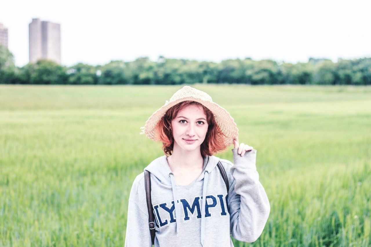 Portrait of young woman standing on grassy field