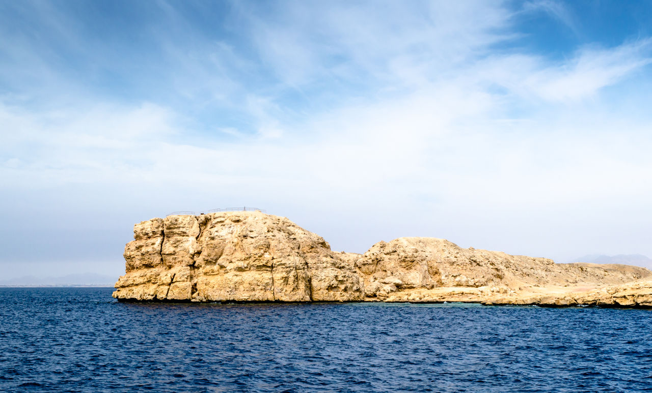 Rock formation in sea against sky