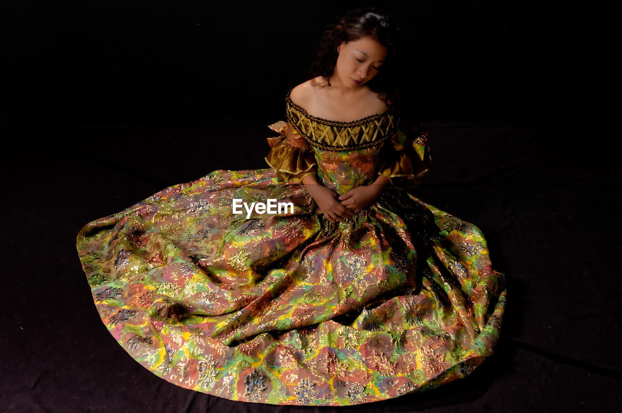 Woman wearing evening gown against black background