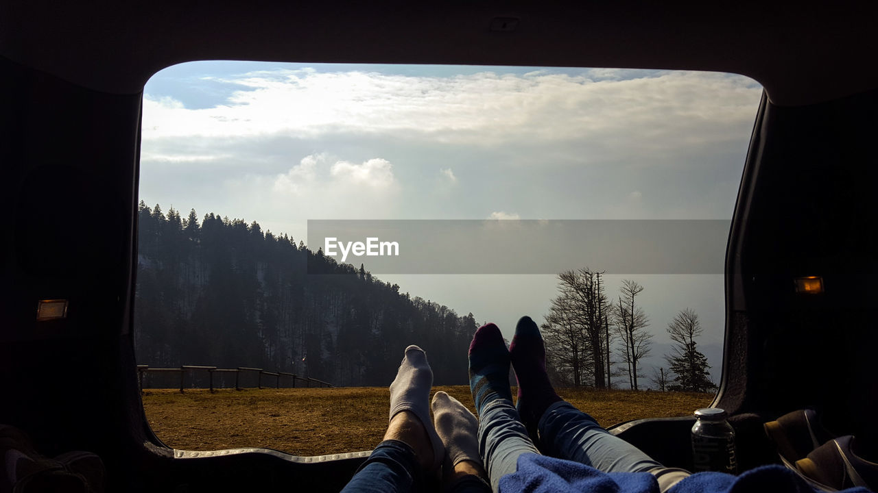 Low section of couple relaxing in motor home on field