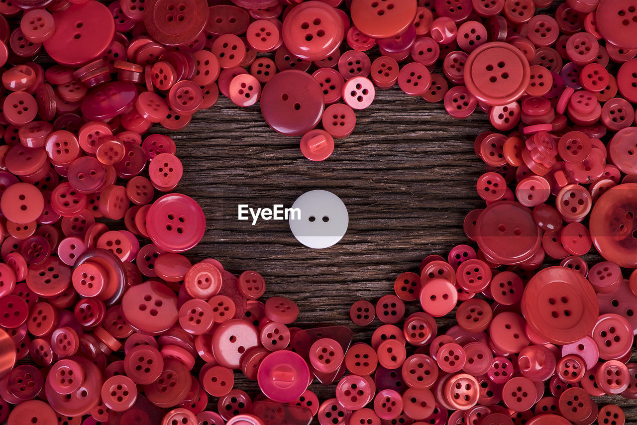 Full frame shot of buttons arranged in heart shape on table 