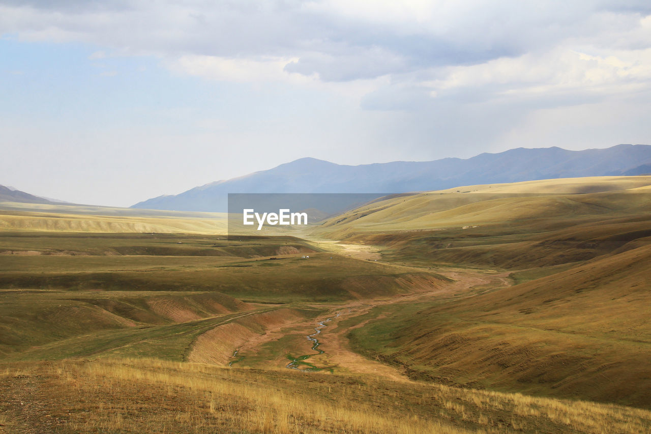 Wide steppe with a river and a distant view of the mountain ranges on the assy plateau in autumn