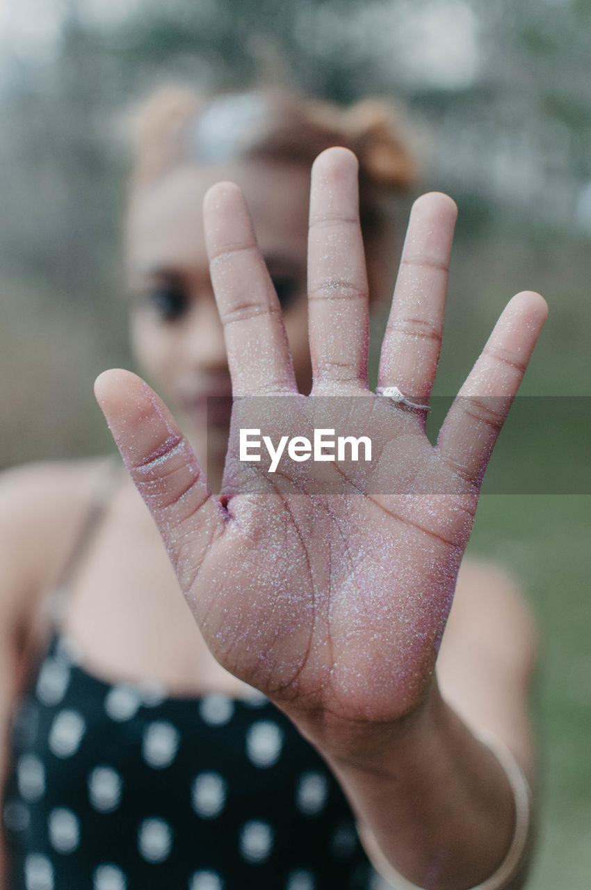 CLOSE-UP OF WOMAN HAND WITH BLURRED BACKGROUND