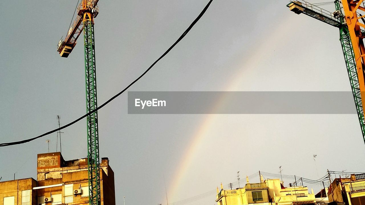 Low angle view of cranes at construction site