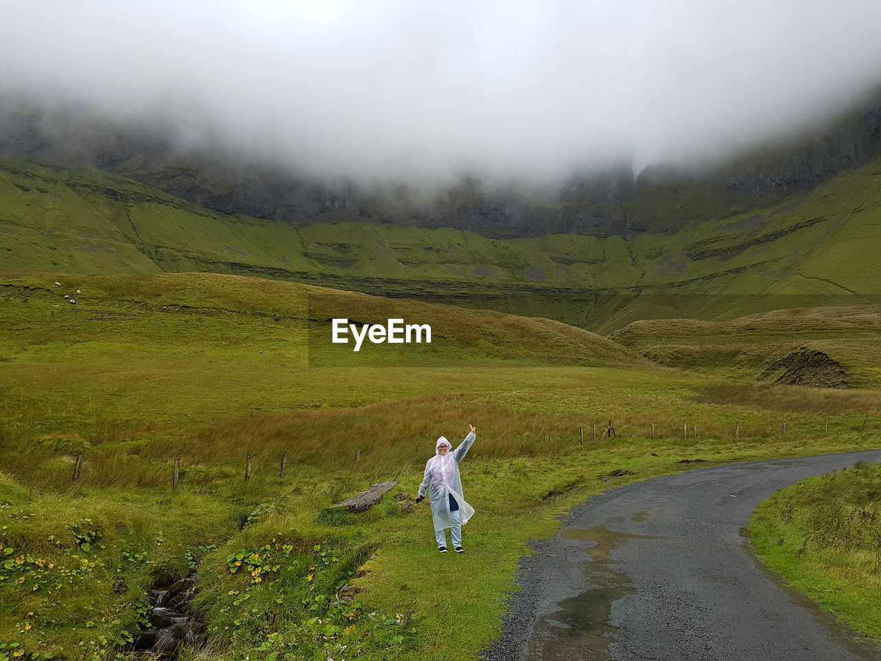 Woman standing against mountain on field