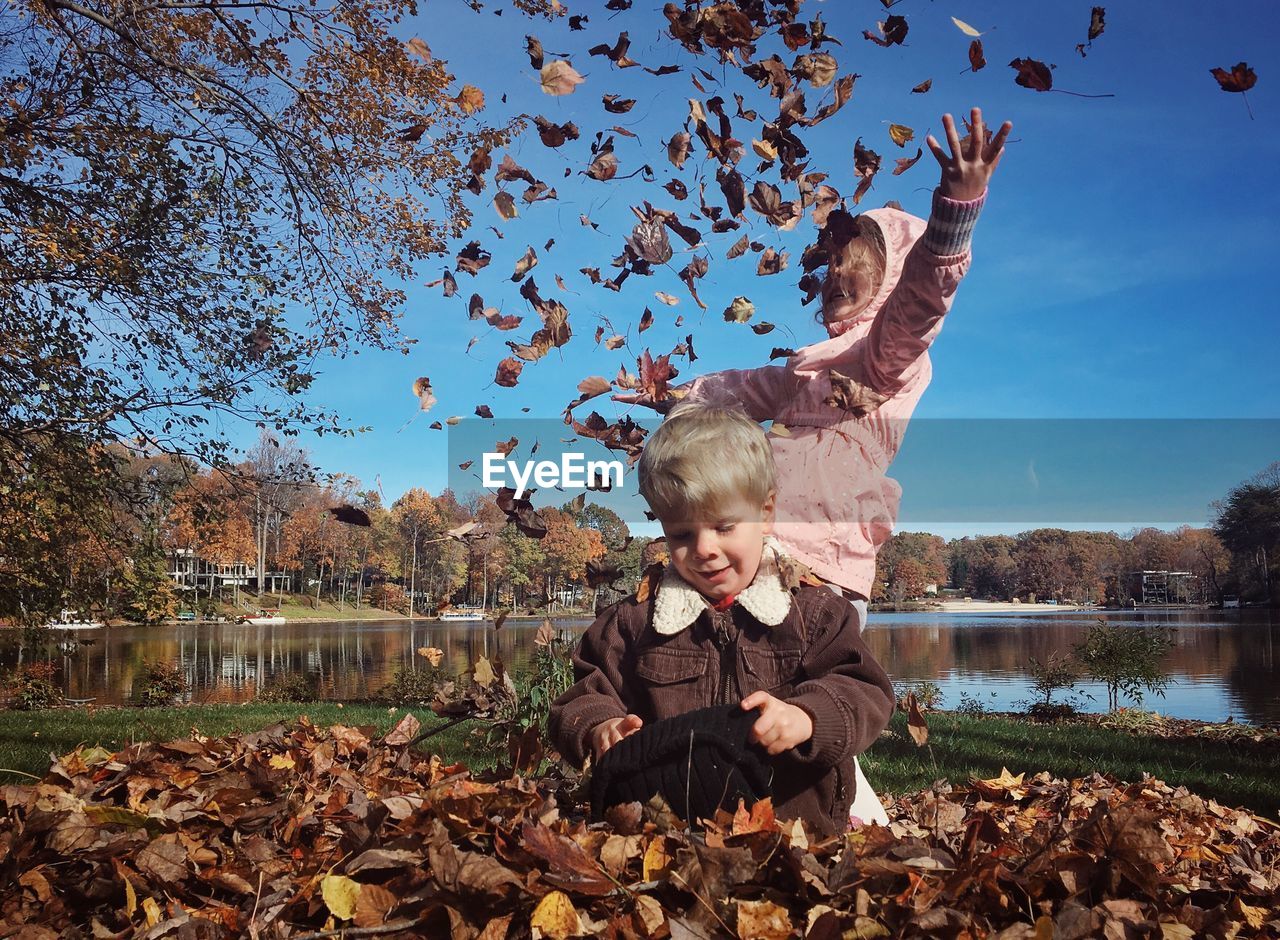 Children playing with autumn leaves at park