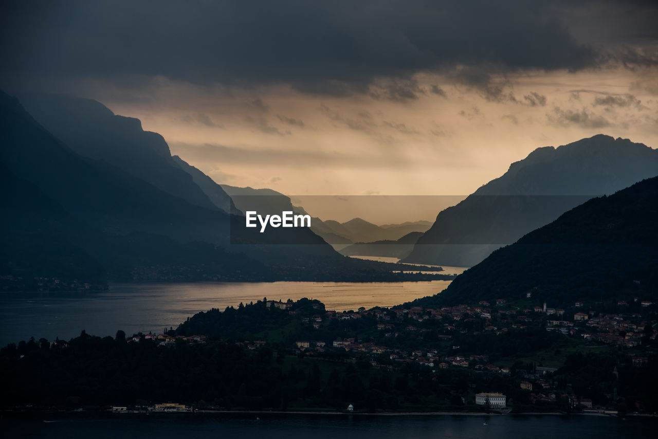 Scenic view of sea and mountains against sky at sunset