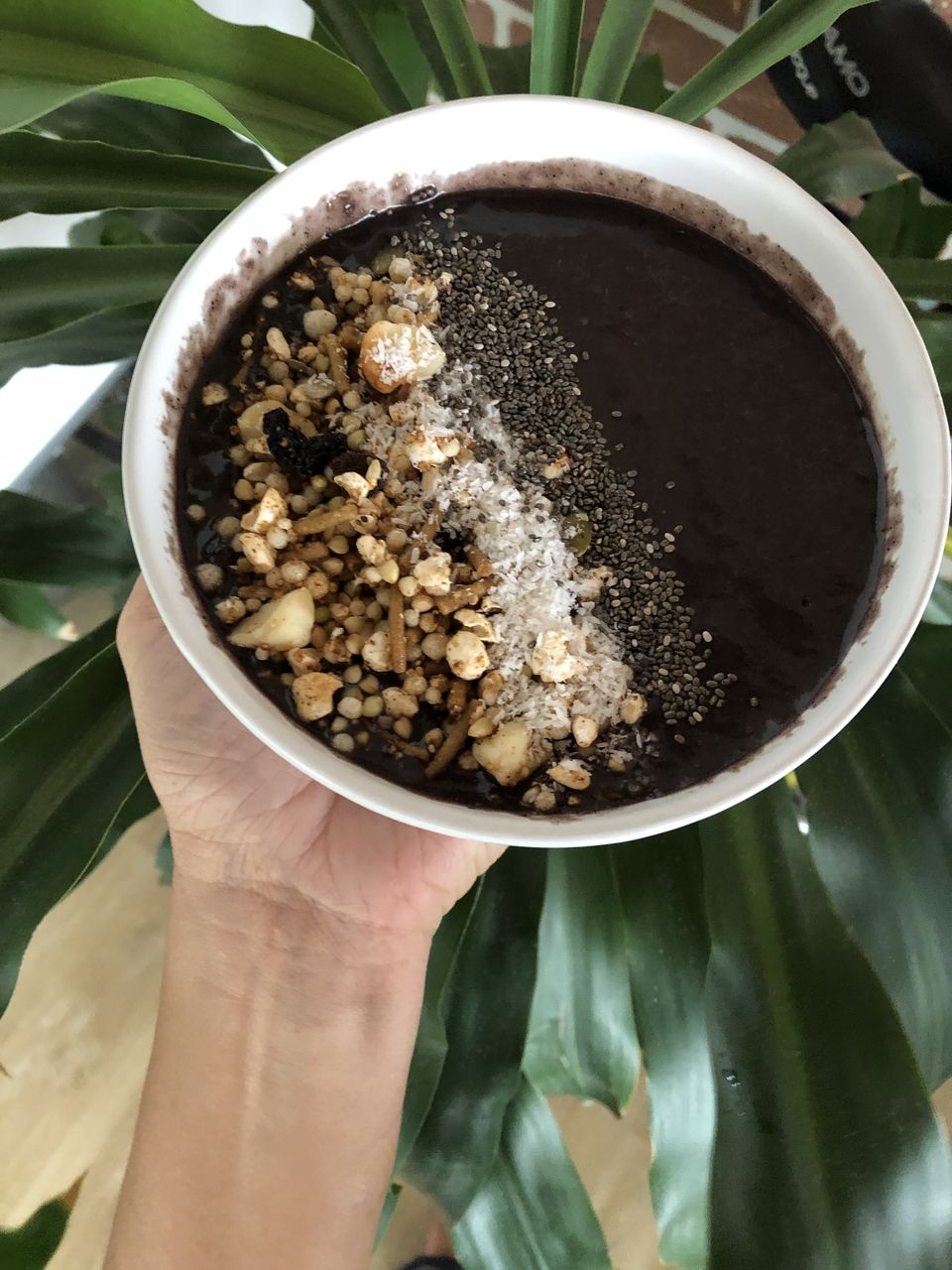 CLOSE-UP OF HAND HOLDING BOWL OF SOUP