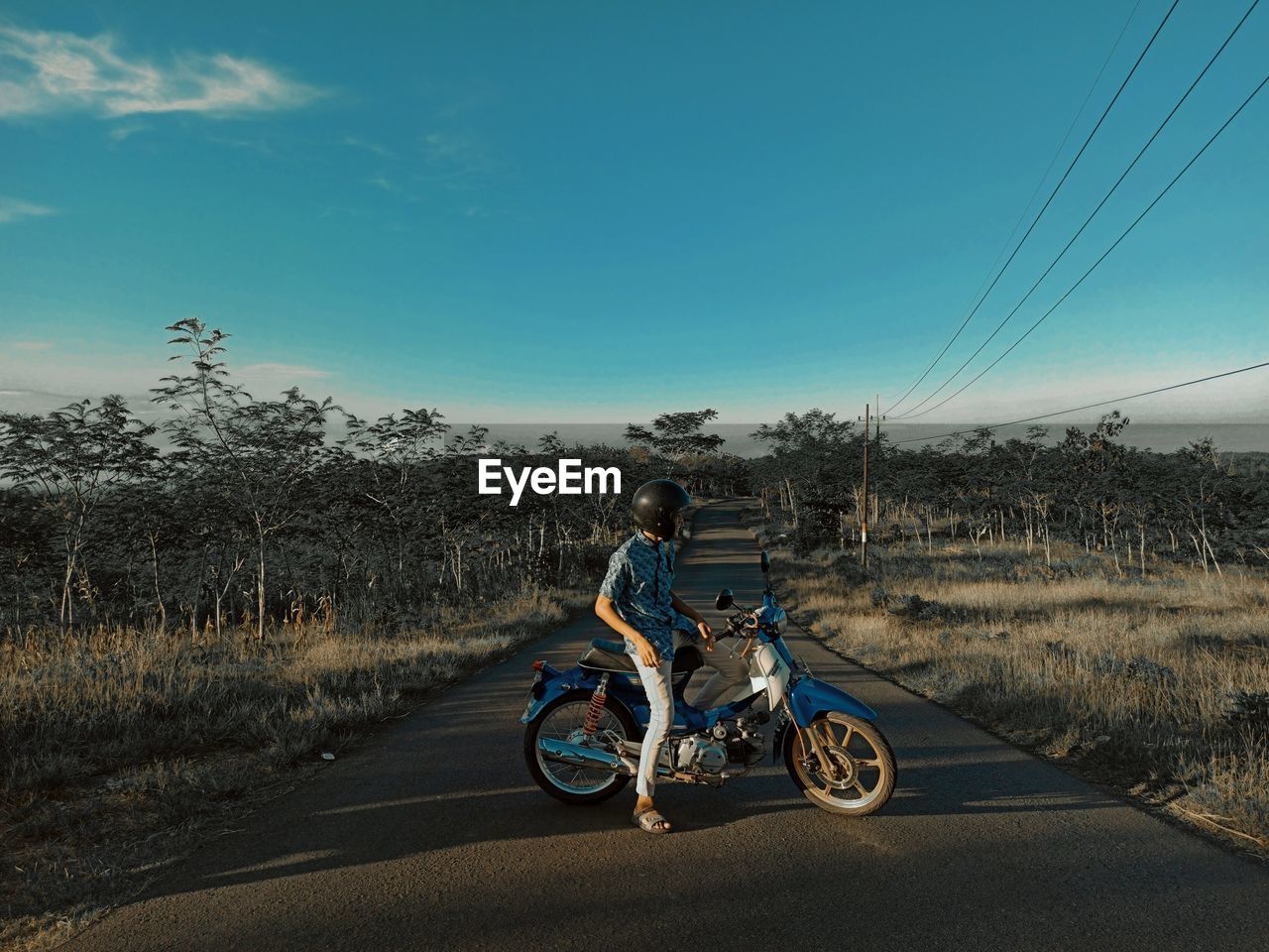 Bicycles riding motorcycle on road against sky