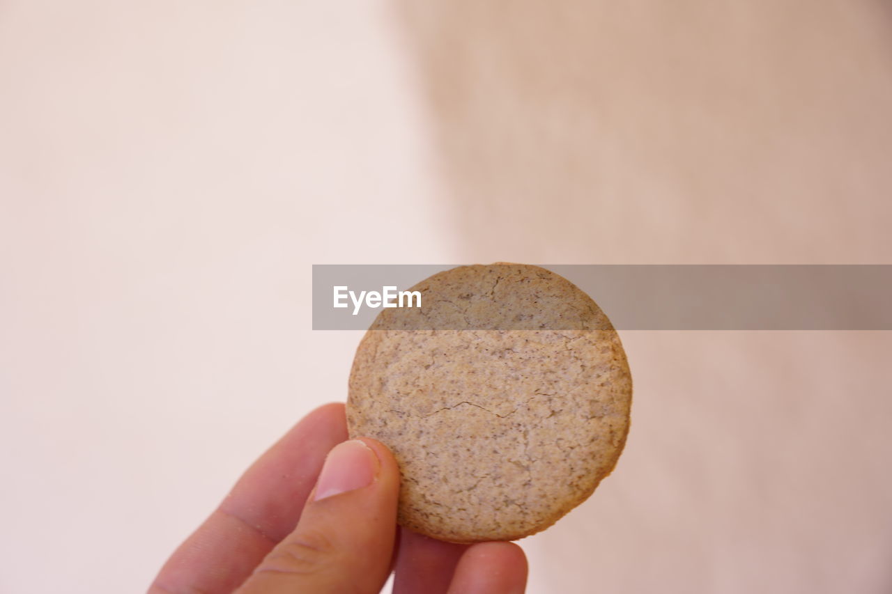 CLOSE-UP OF HAND HOLDING BREAD