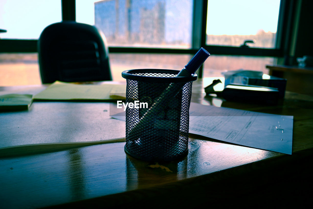 CLOSE-UP OF GLASS WINDOW ON TABLE AGAINST THE WALL