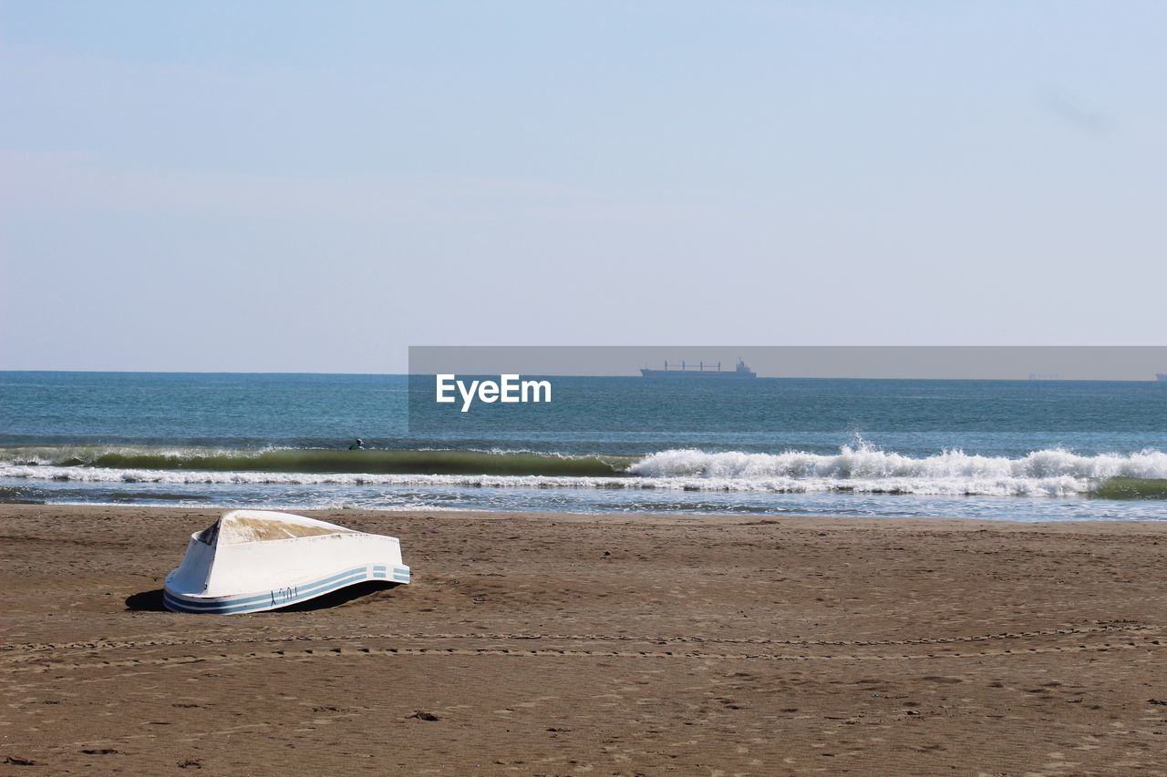 Deck chairs on beach against clear sky