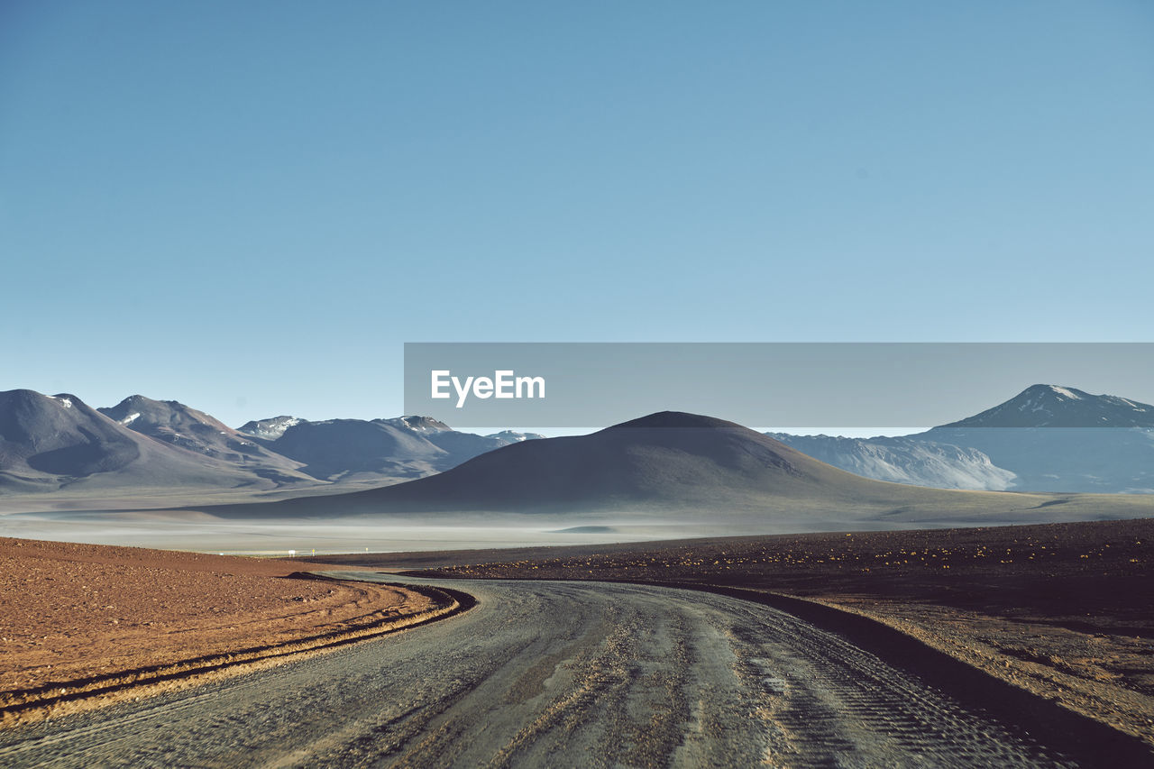 Scenic view of snowcapped mountains against clear blue sky