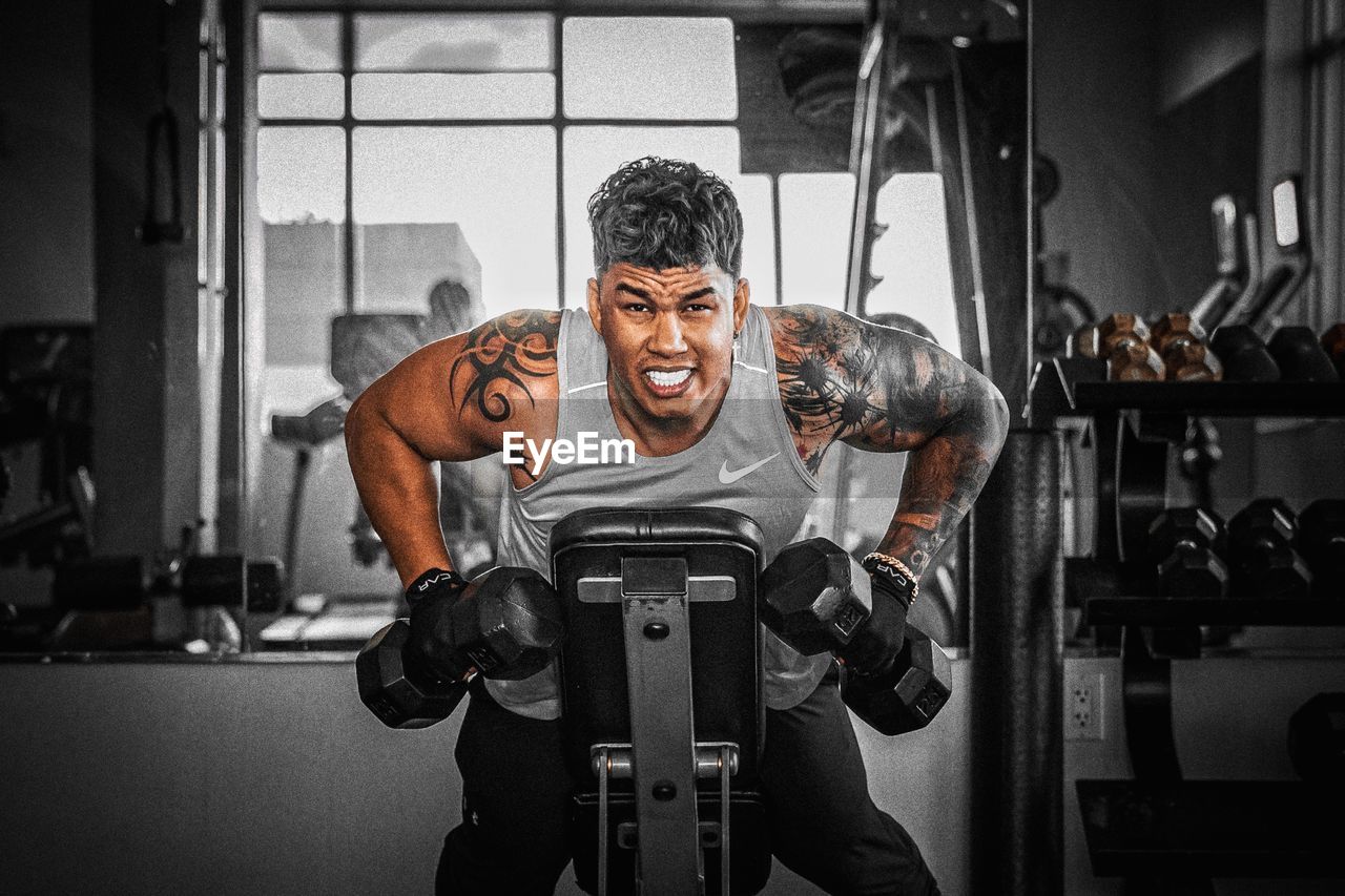 low angle view of young man sitting in gym