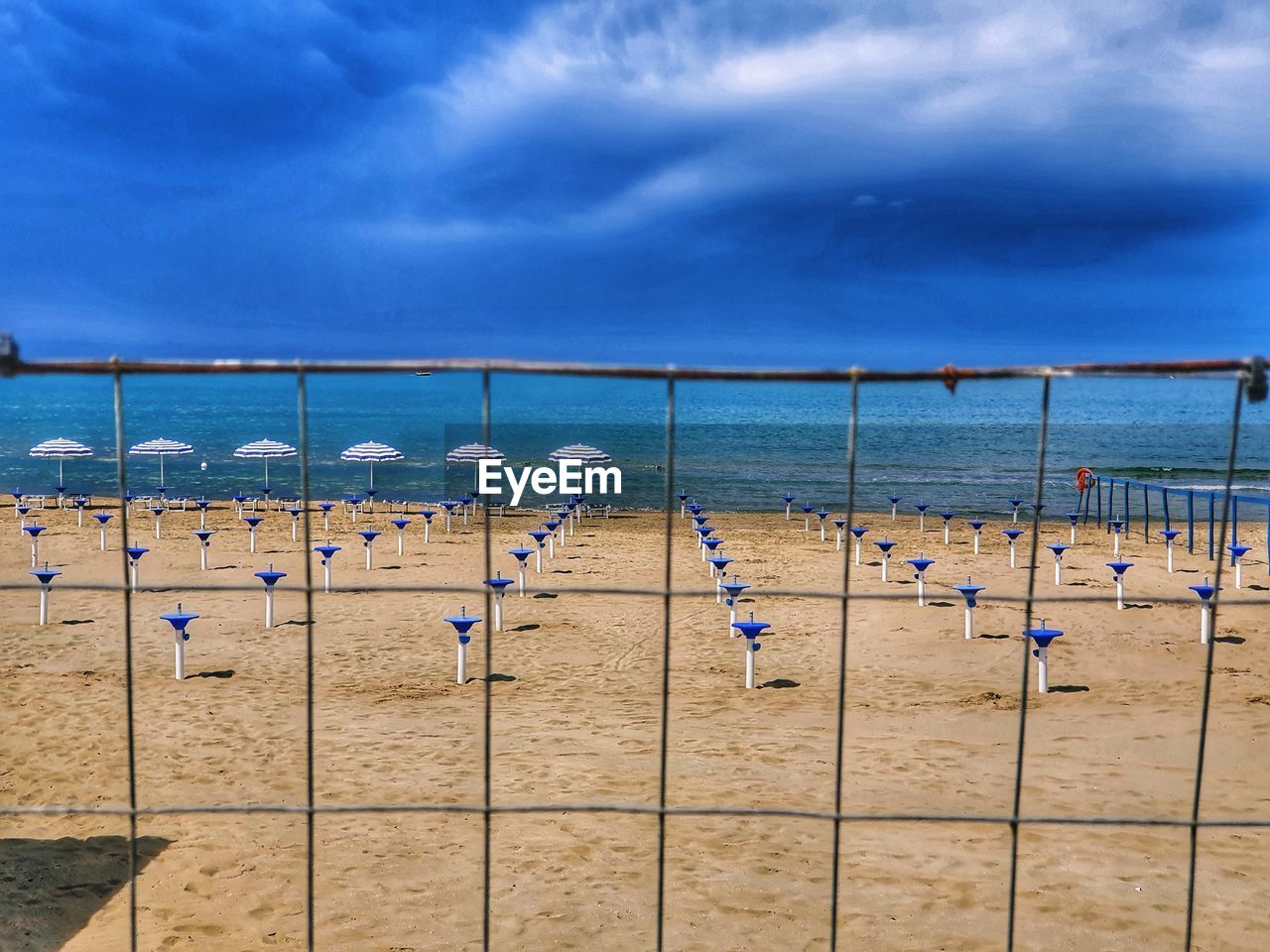 Lounge chairs on beach against sky