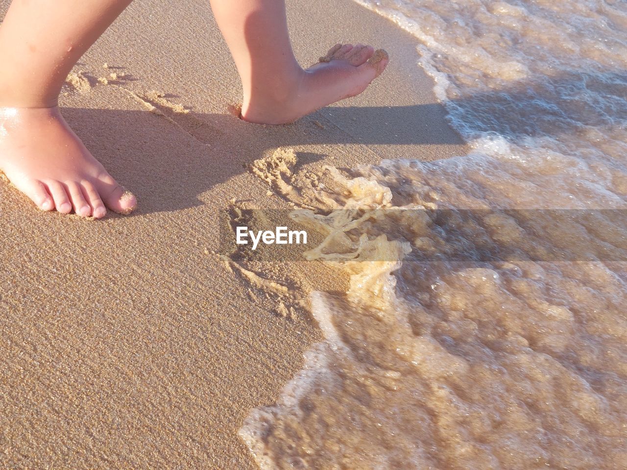 beach, sand, land, barefoot, low section, one person, vacation, trip, human leg, nature, holiday, leisure activity, water, sunlight, day, high angle view, women, sea, human foot, lifestyles, summer, childhood, limb, child, human limb, adult, outdoors, standing, shadow, travel, floor, wet, relaxation, hand, footprint, motion, water sports, enjoyment, female