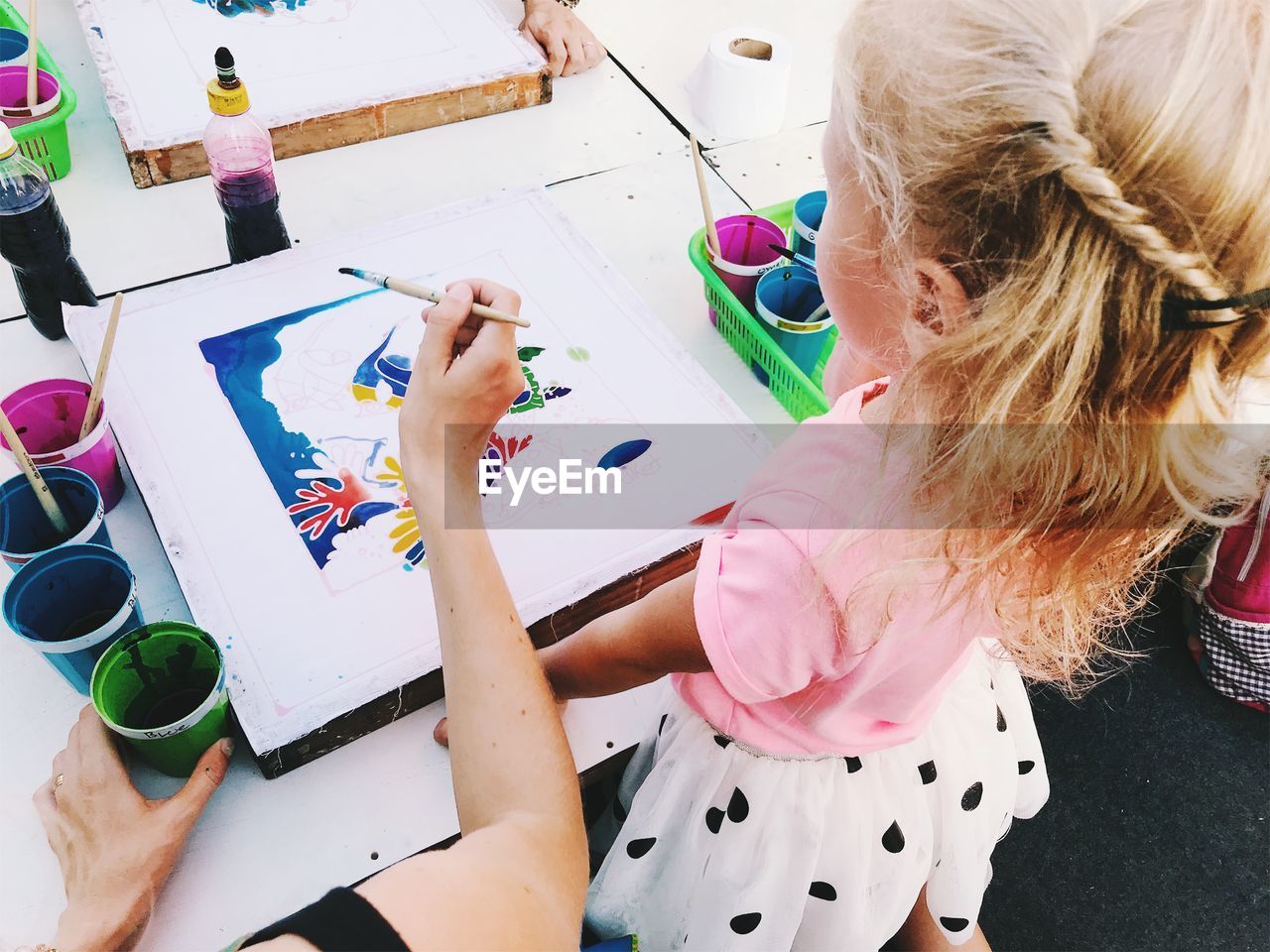 High angle view of mother and daughter making drawing on table