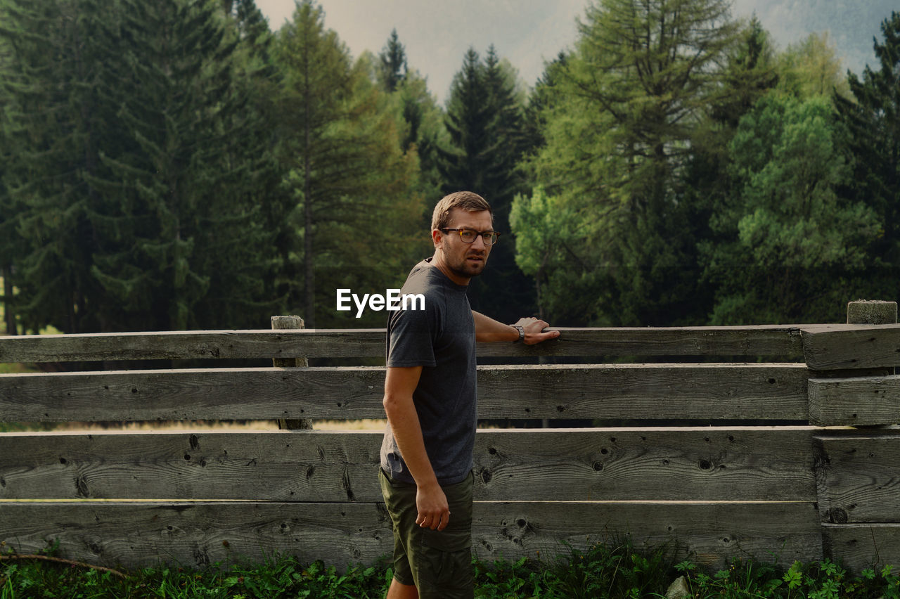 Full length of man standing on bench against trees