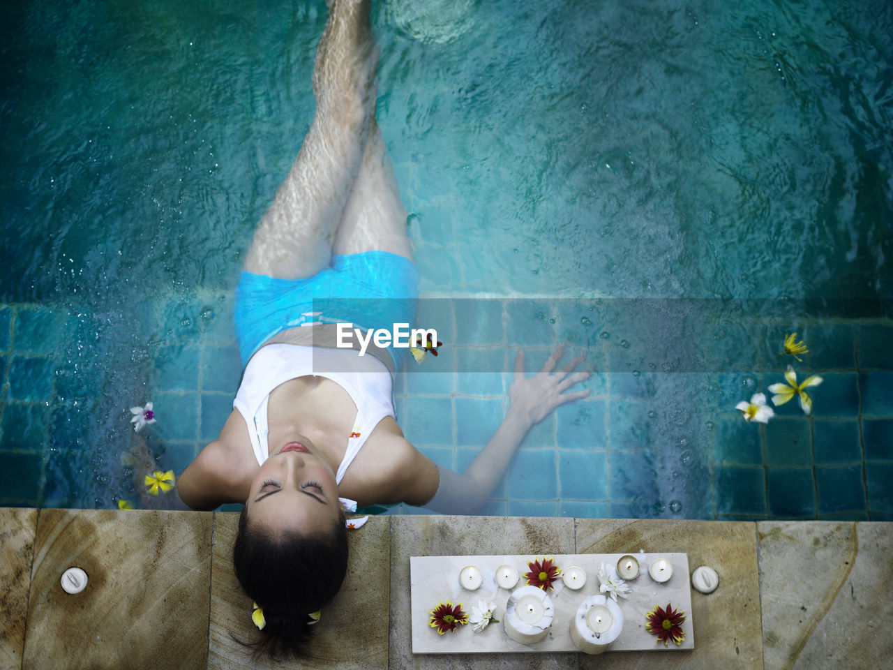 High angle view of young woman relaxing in swimming pool