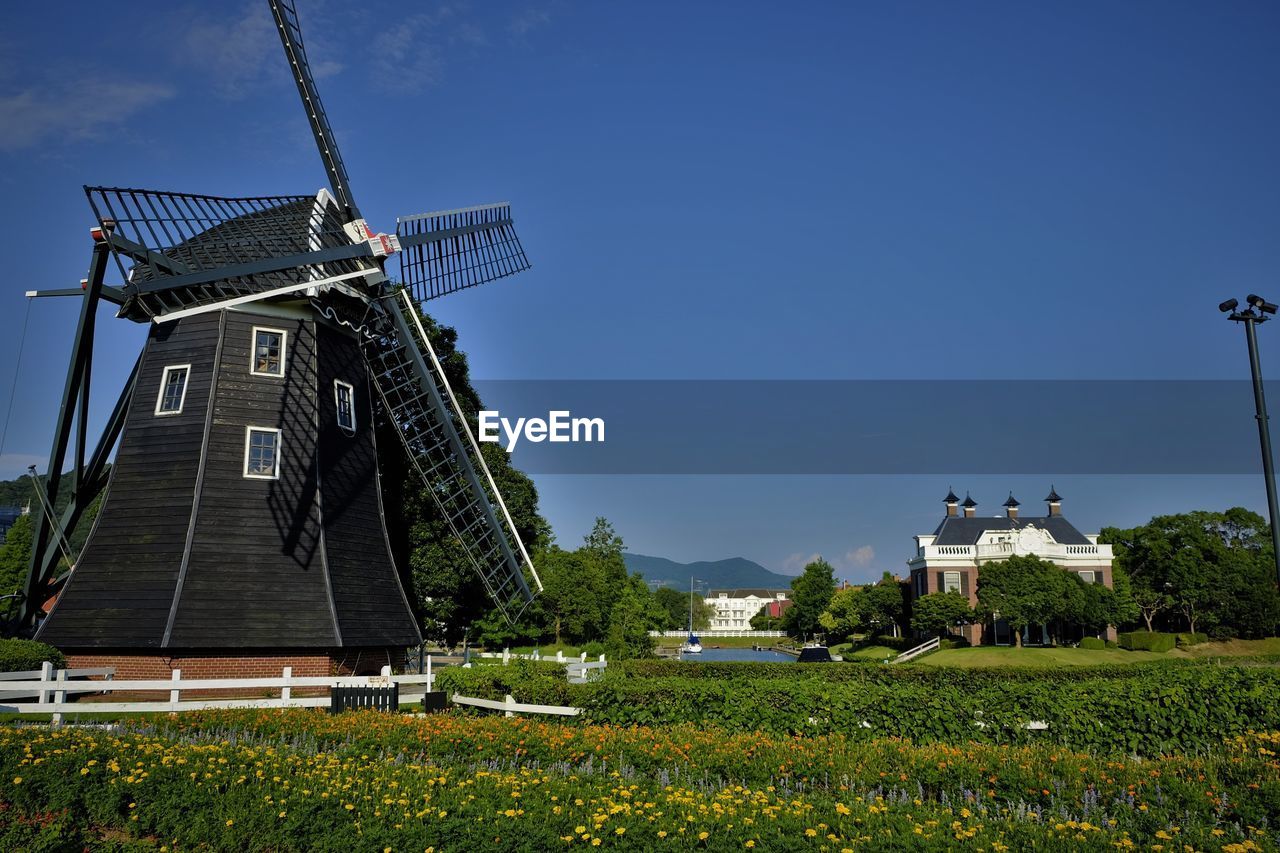 Traditional windmill on field against sky