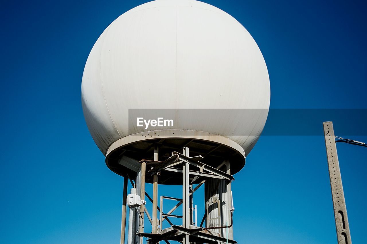 Low angle view of illuminated tower against blue sky