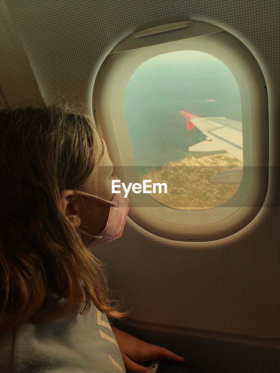 Girl looking at airplane window