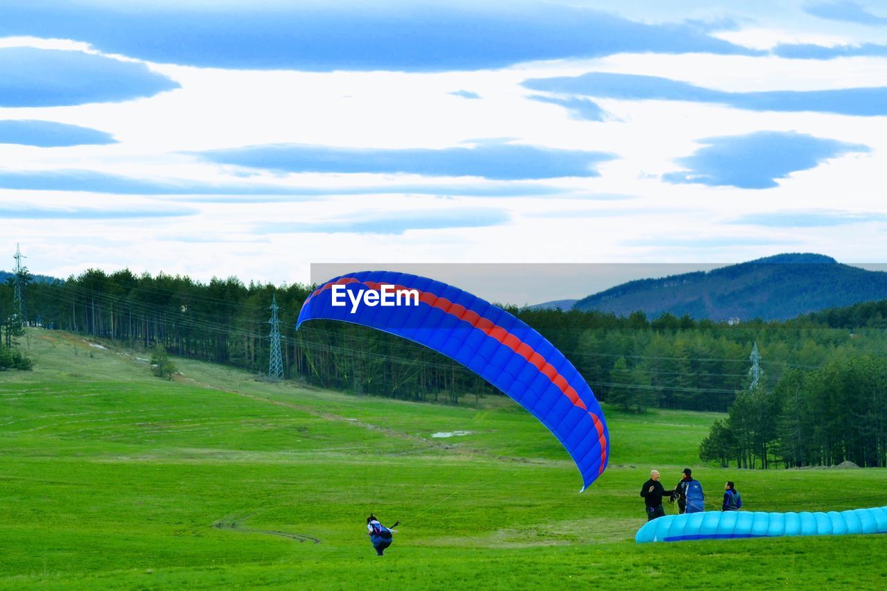 PEOPLE IN FIELD AGAINST SKY