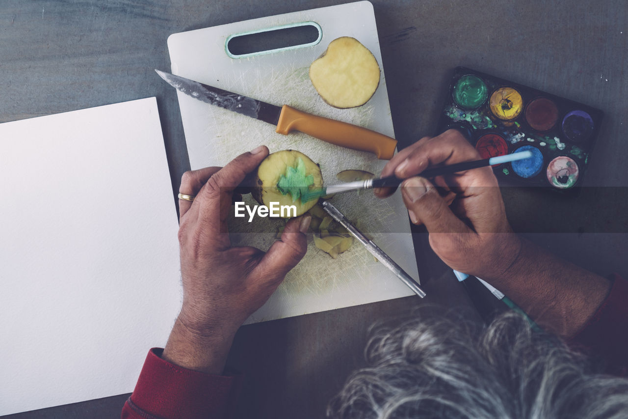 Directly above view of man painting on fruit