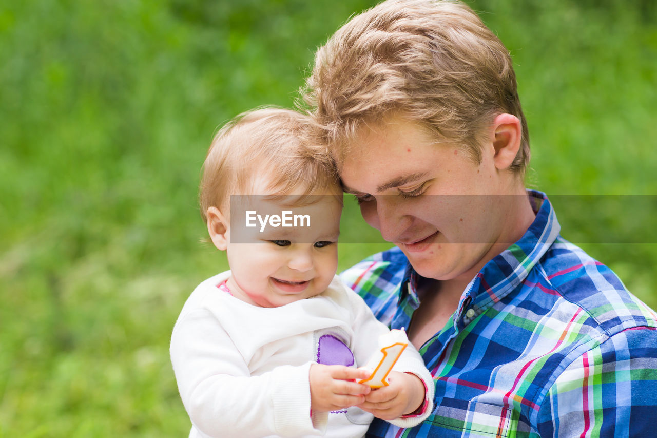 PORTRAIT OF CUTE BOY HOLDING BABY