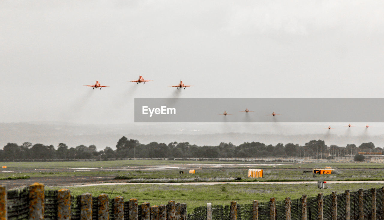 AIRPLANE FLYING OVER FIELD