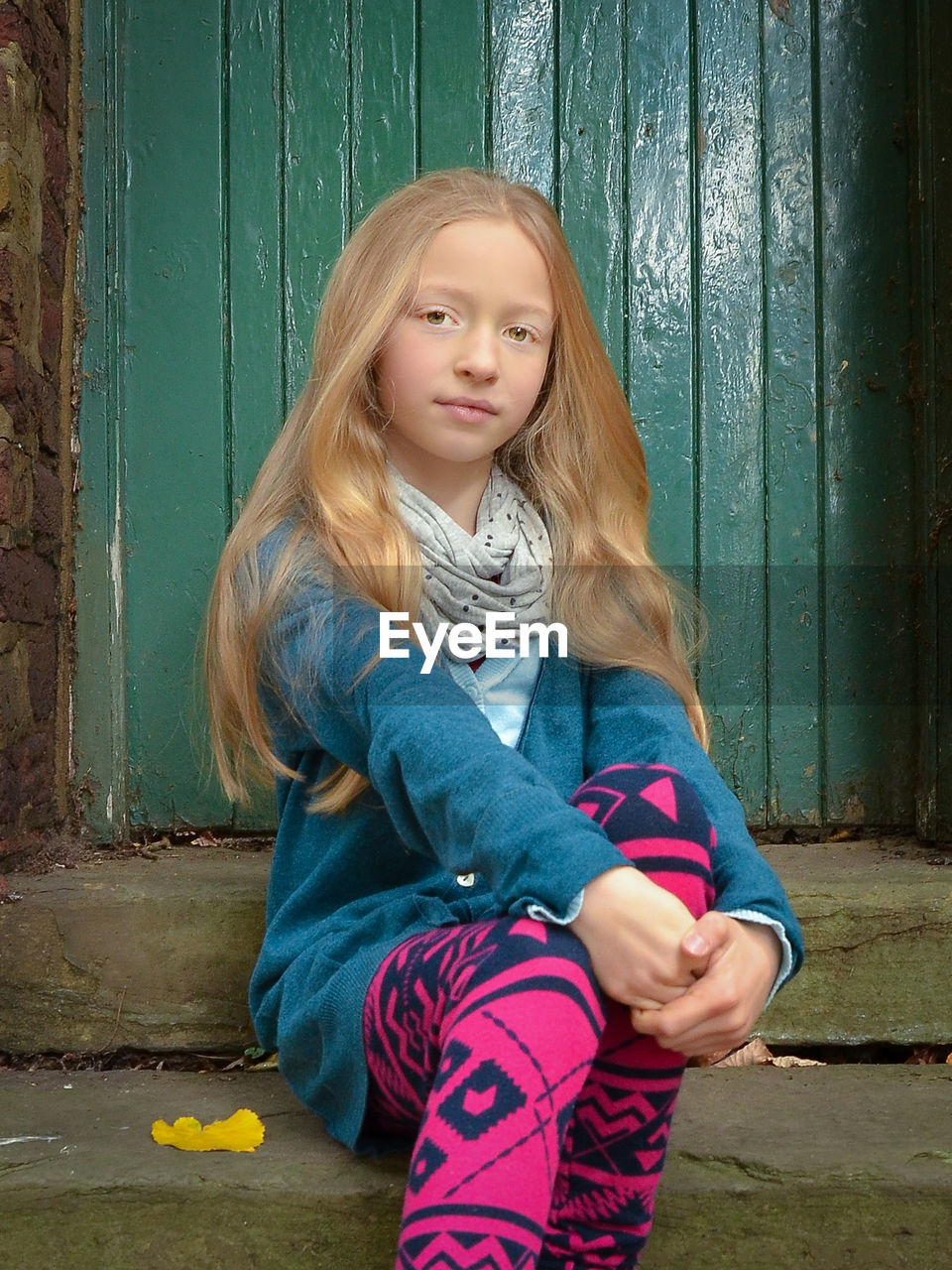 Portrait of girl sitting at entrance