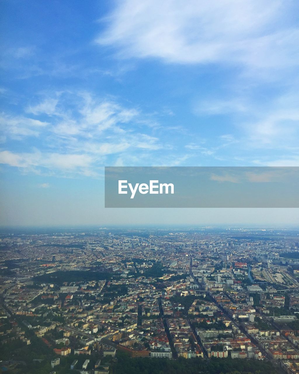 Aerial view of cityscape against cloudy sky